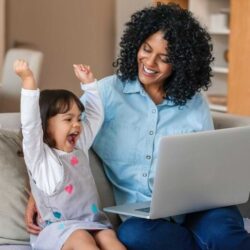 Aws Laughing Little Girl And Mother Watching Something On A Laptop