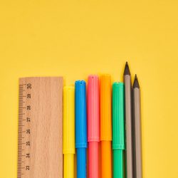 Ruler With Pencils And Colorful Pens On Yellow Background