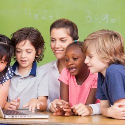 Aws Teacher With 4 Students Gathered Around A Laptop Smiling