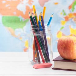 Aws Colored Pencils In Mason Jar Next To Books C Eraser C And An Apple On Top Of A Book